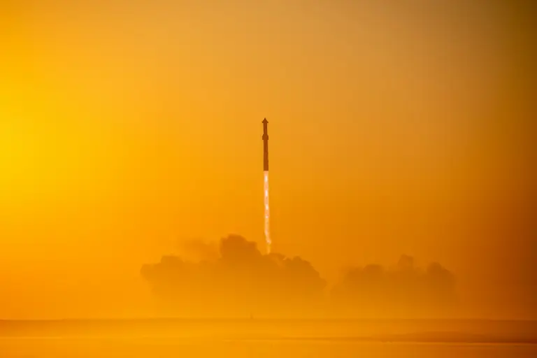 SpaceX’s Starship launches into space against a golden sky, leaving a bright trail of rocket flames. This historic SpaceX launch marks another step toward deep-space exploration and future Mars missions. 