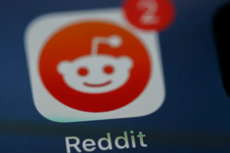 Close-up of the Reddit app icon with notification badges, representing online discussions and community queries about solar incentives in the UK.